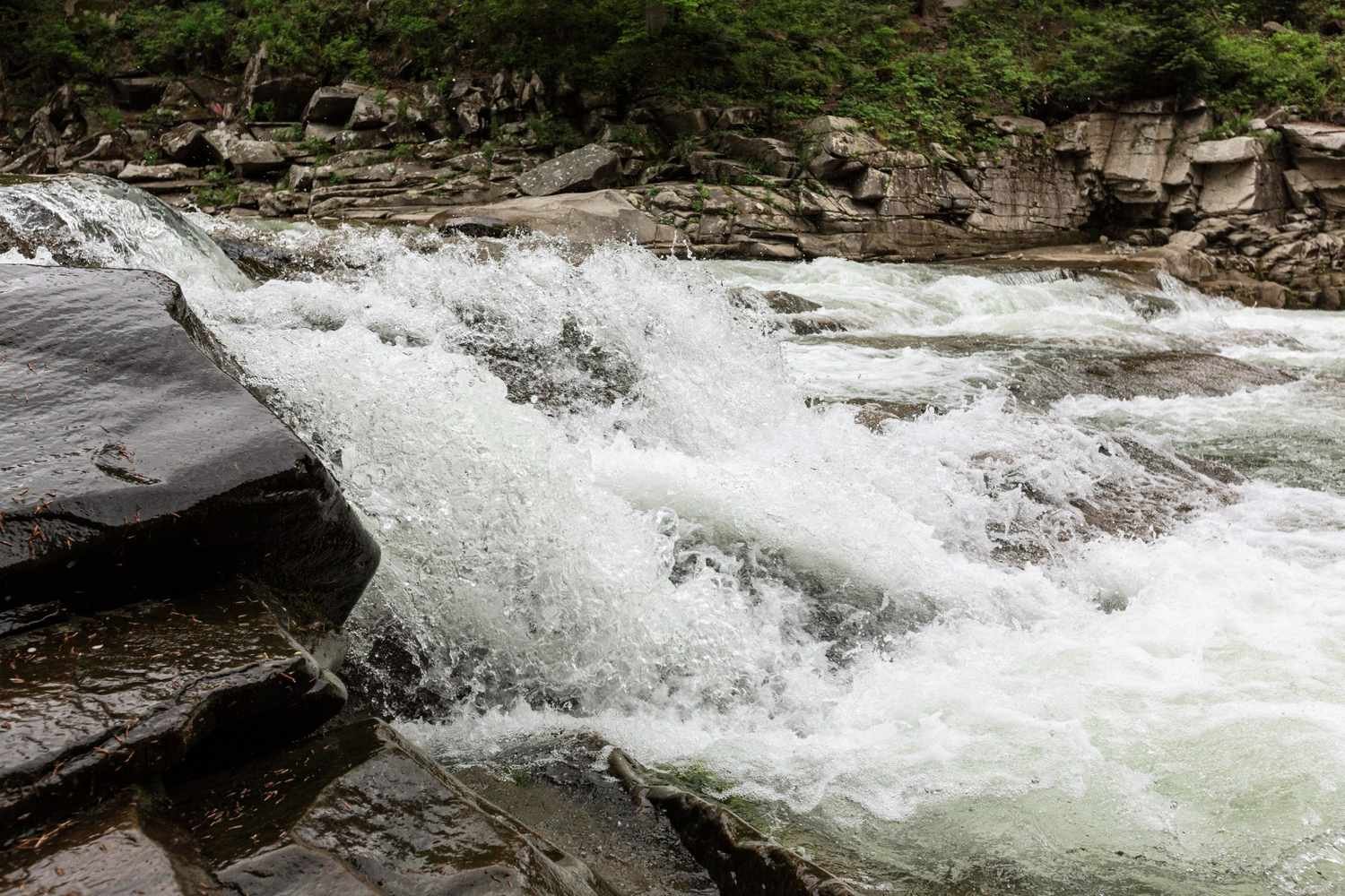 Fast-moving water over a rocky channel in a protected landscape